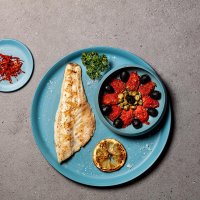 Filete de branzino con tomates, aceitunas y alcaparras